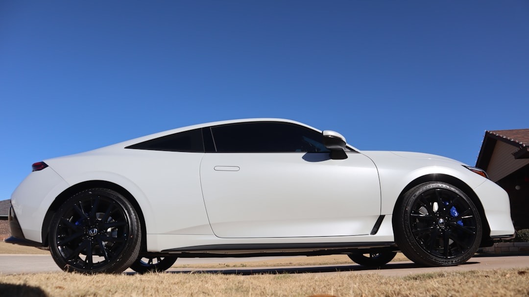 White sports car parked under a clear blue sky.